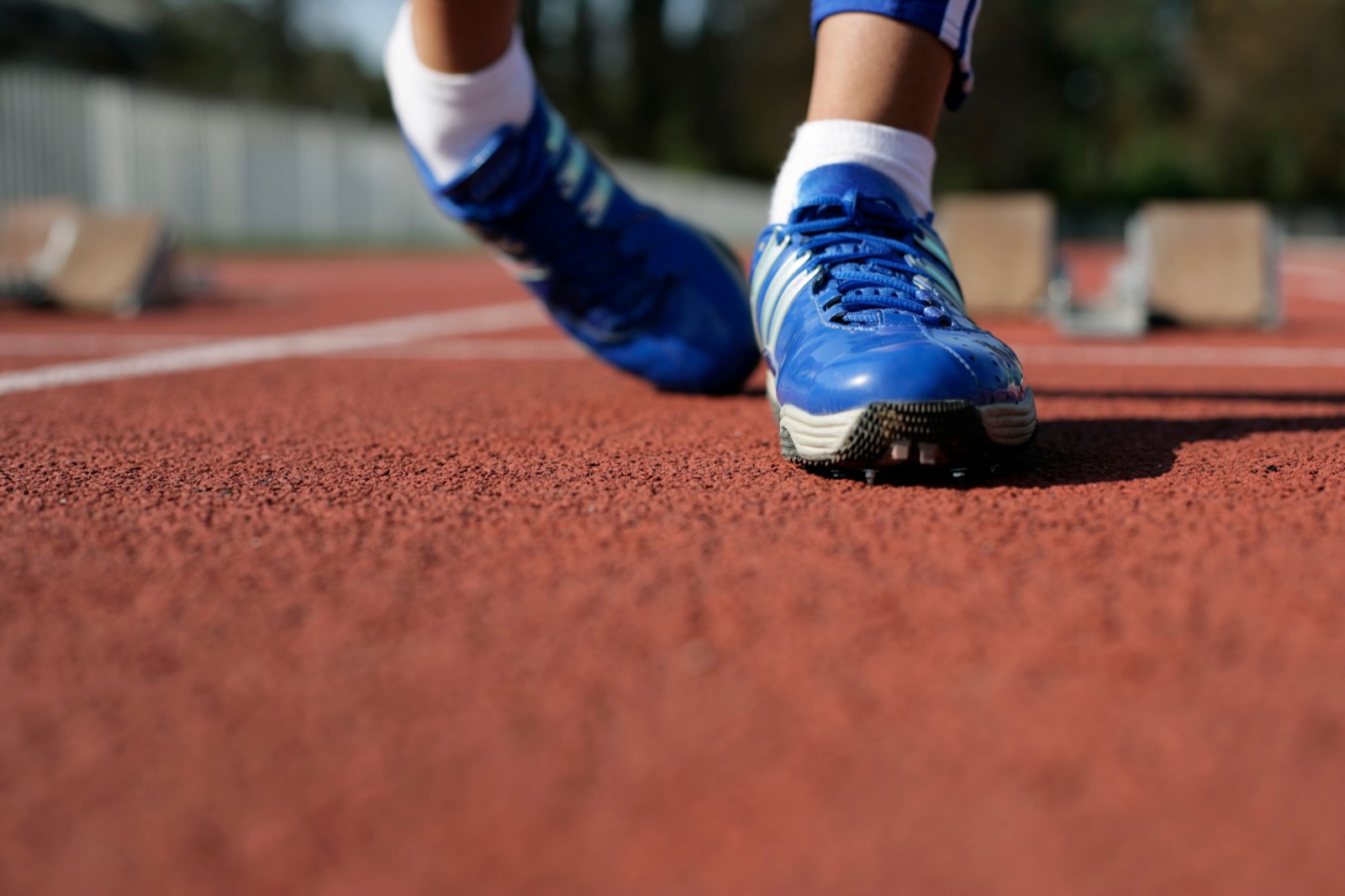 Runner wearing blue running shoes on a track