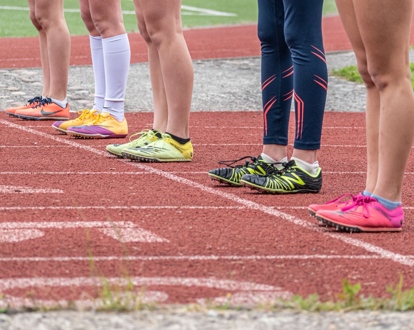 Runners lined up on a track wearing running shoes