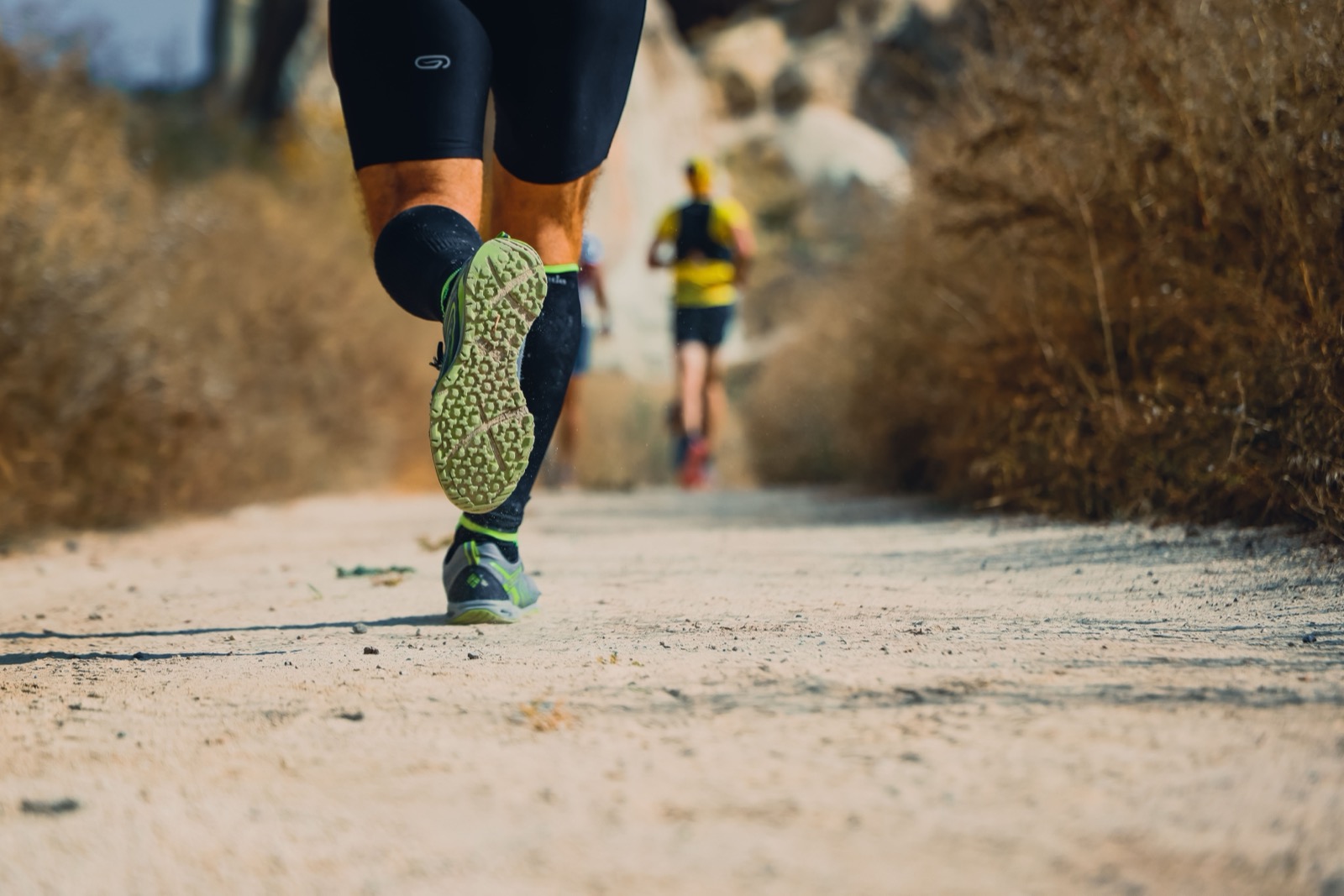 Close-up of runners' shoes on a trail